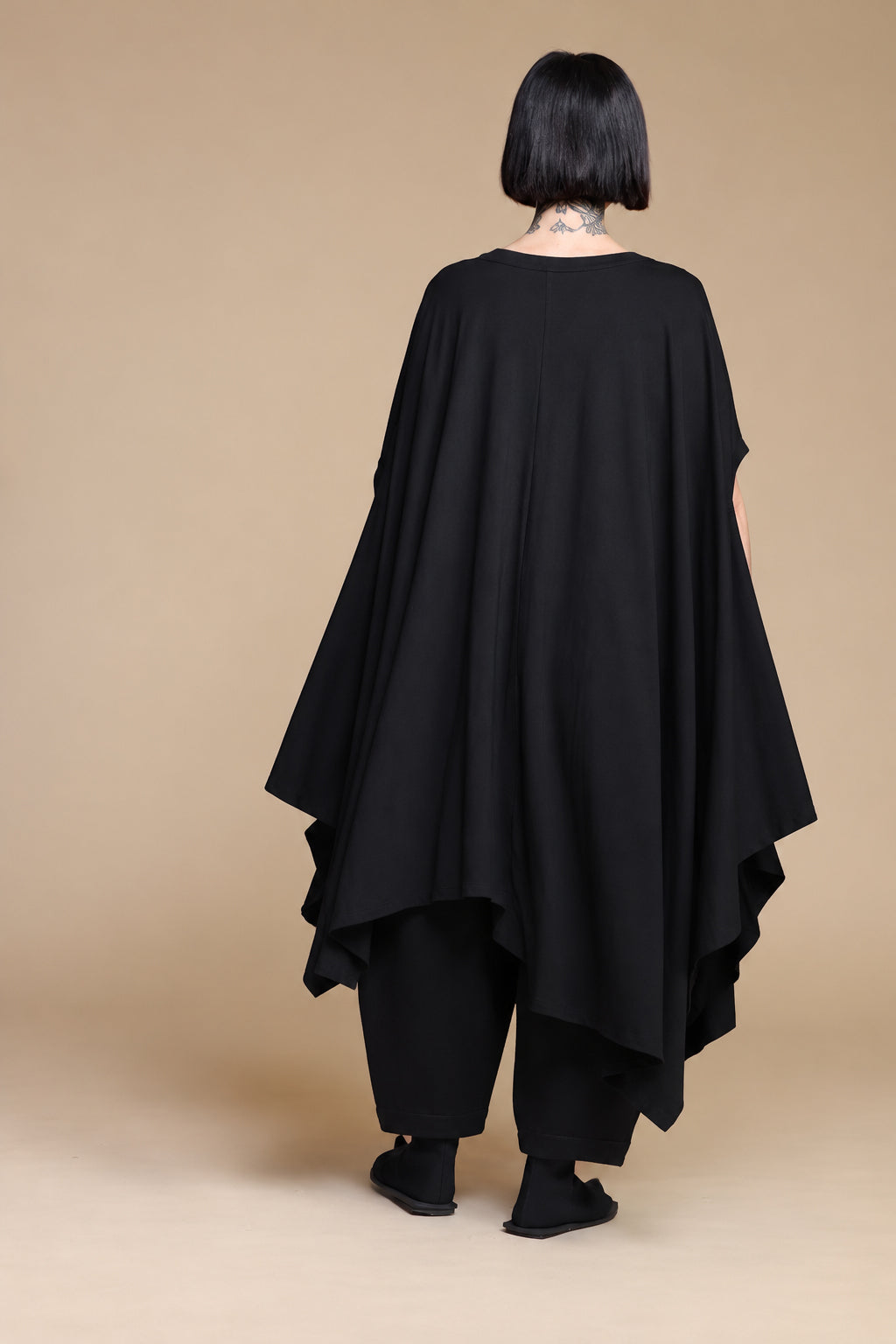 Black draped top, back view showing the long uneven hem