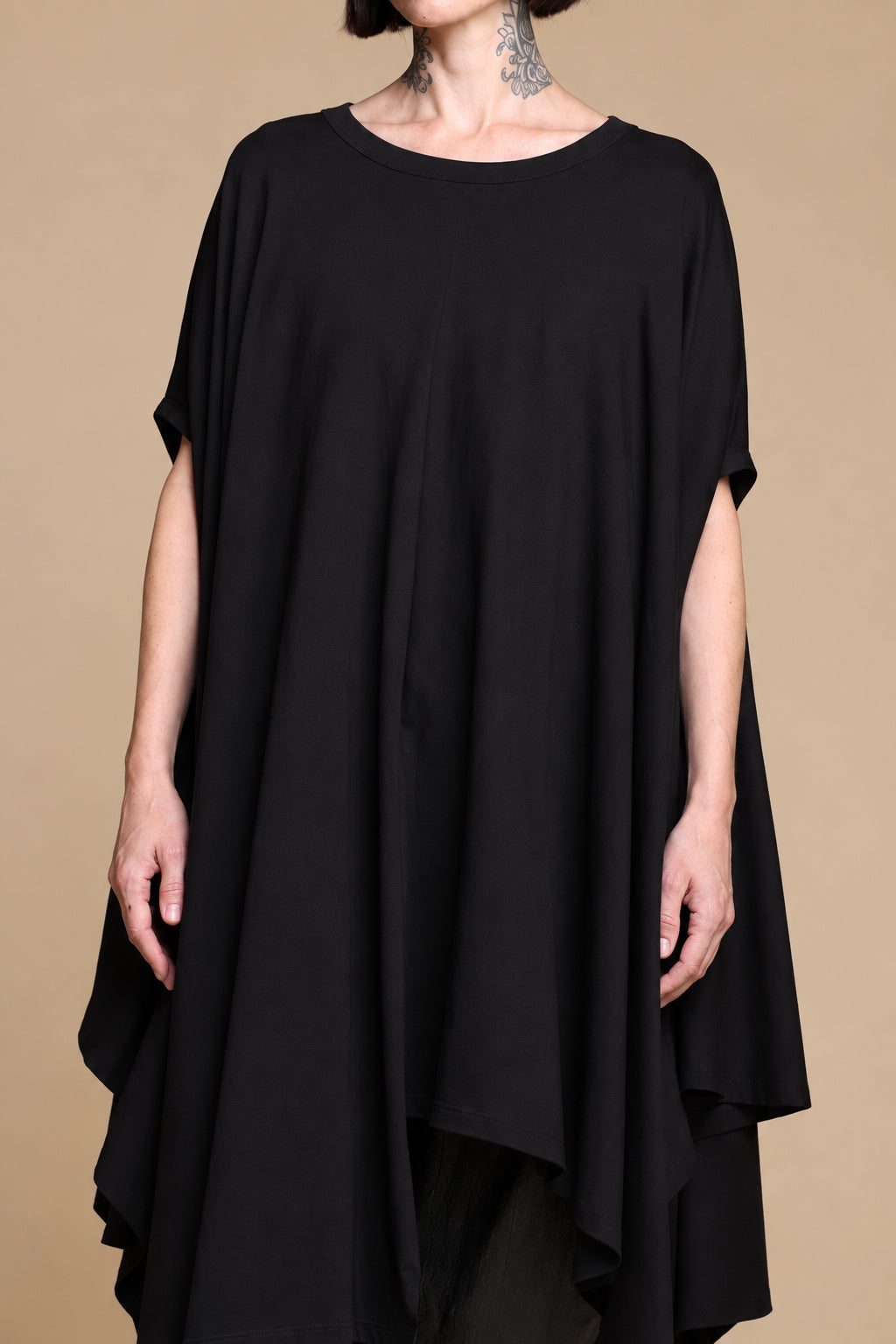 Black draped top, close-up of the round neckline and flowing fabric