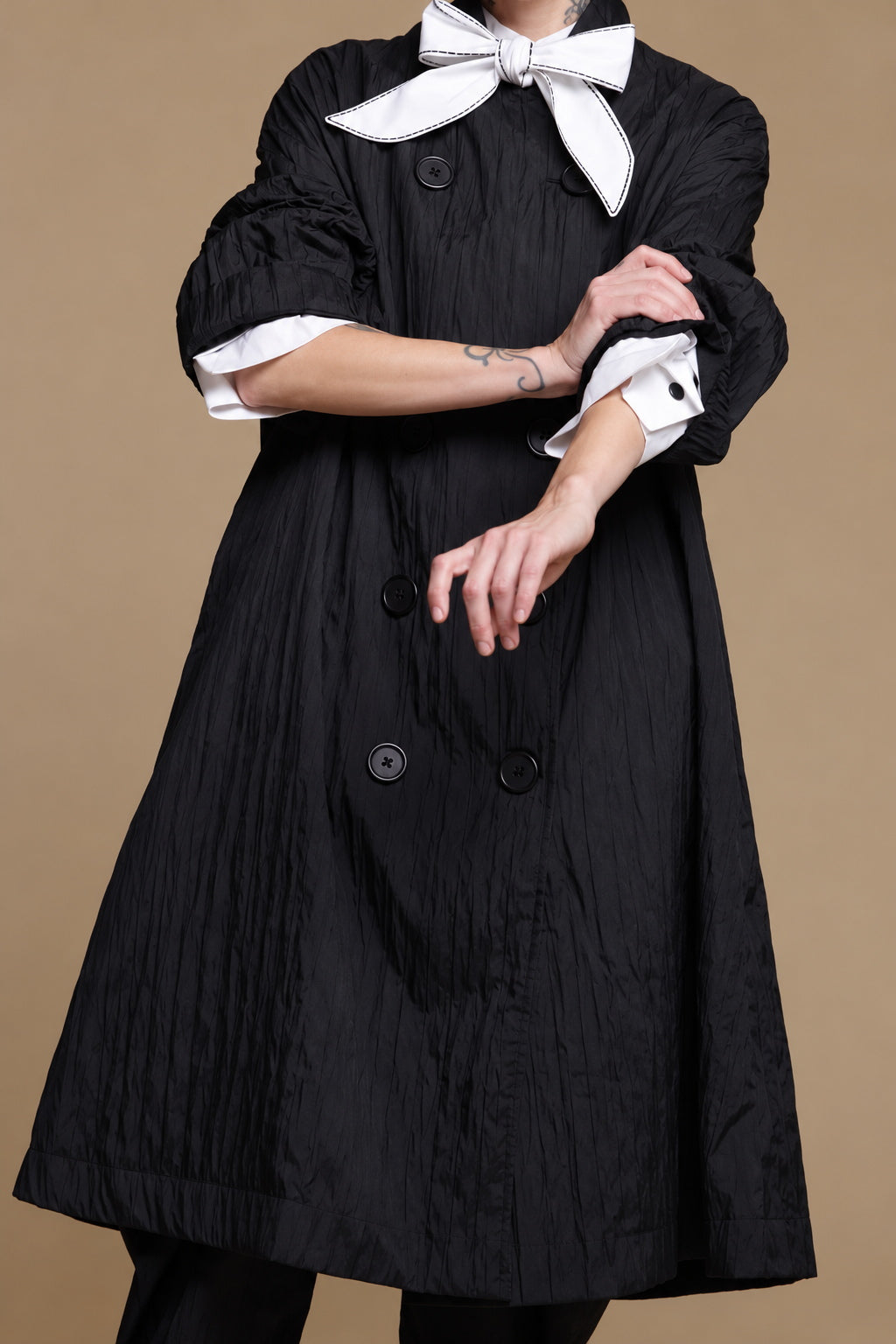 Black crinkle jacket, close-up of the textured fabric and large buttons