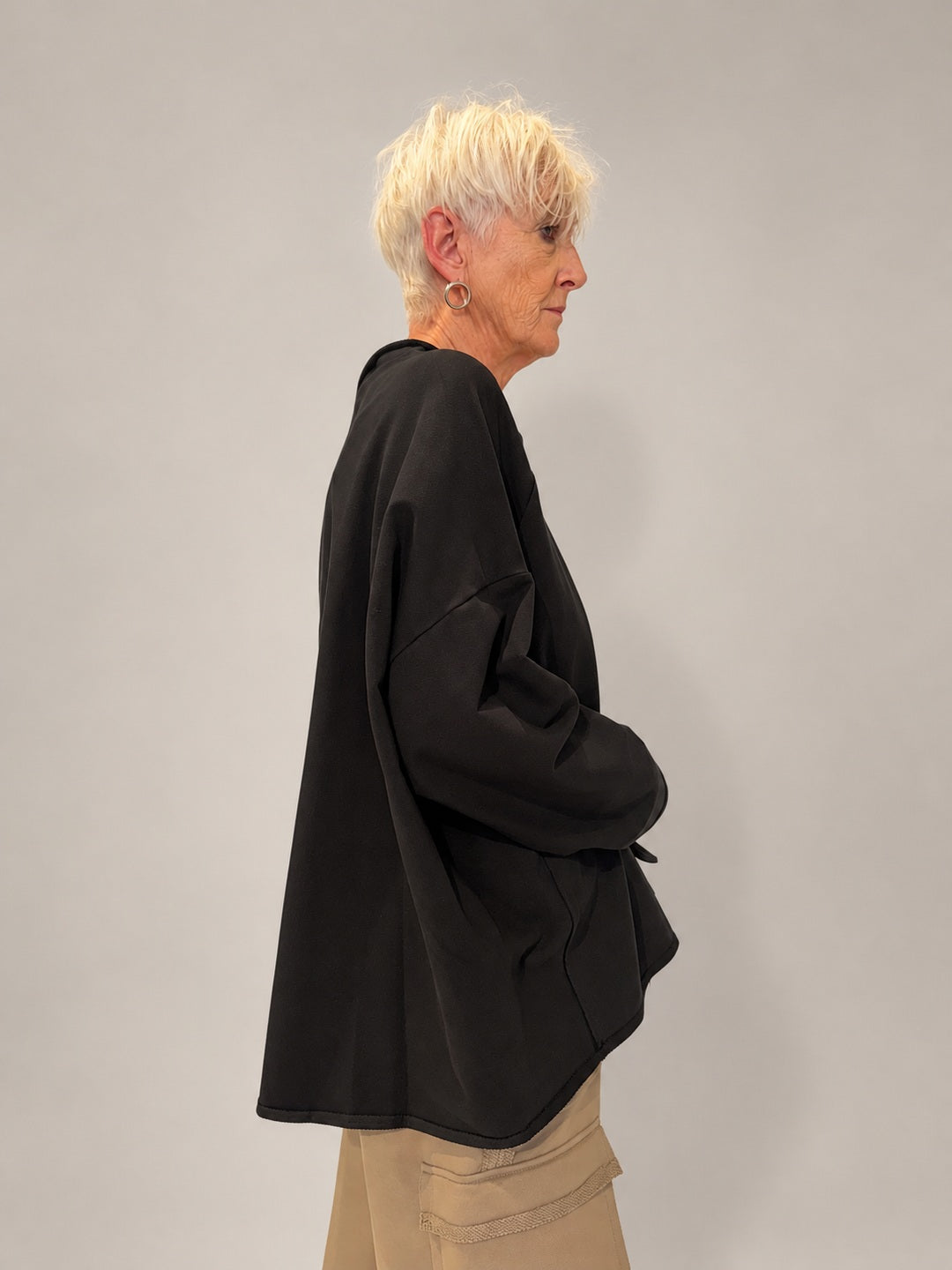 Kedziorek black floral print top, side view showing relaxed volume and curved hem