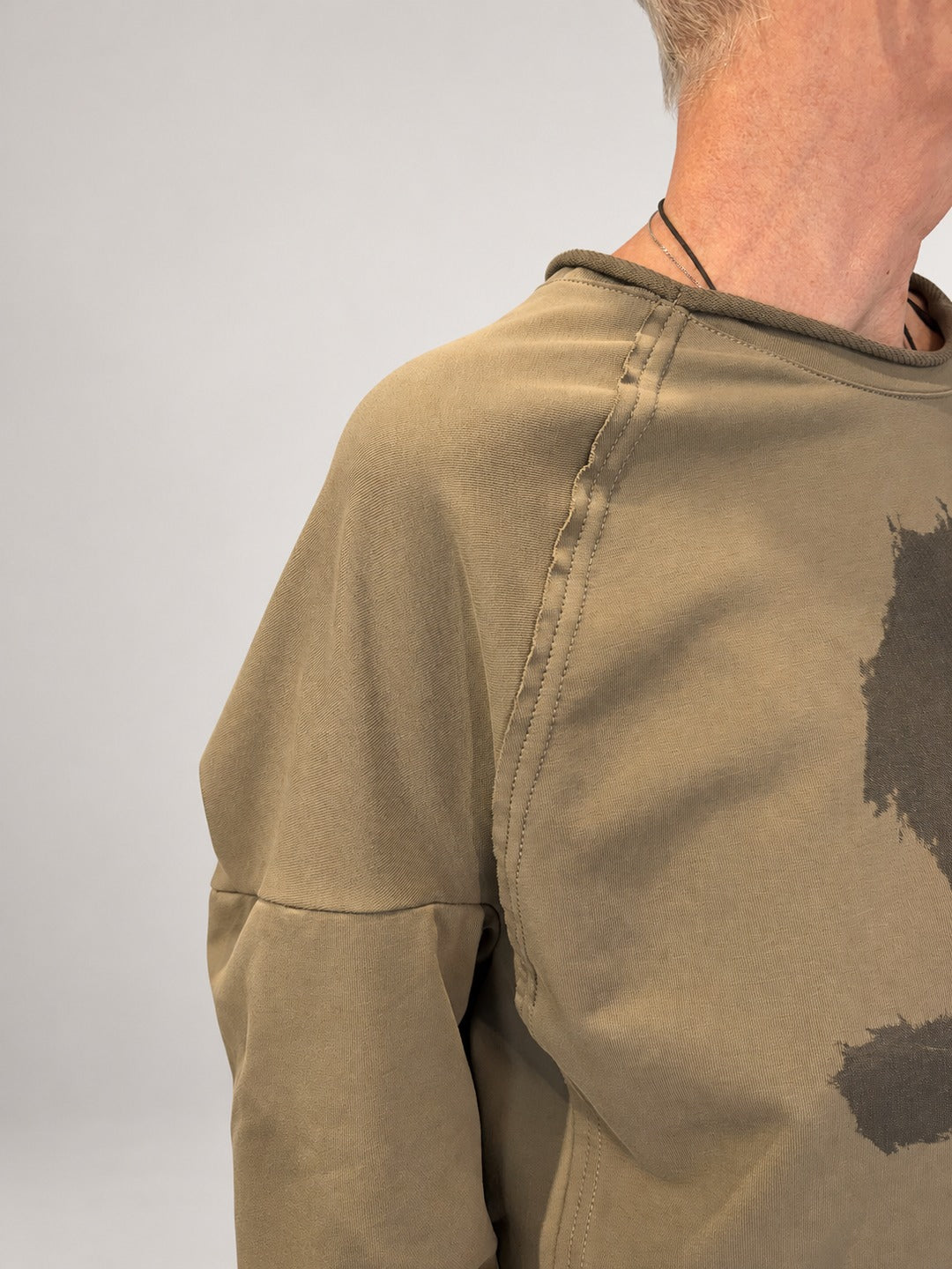 Kedziorek taupe floral print top, close-up of rolled neckline and exposed shoulder seam