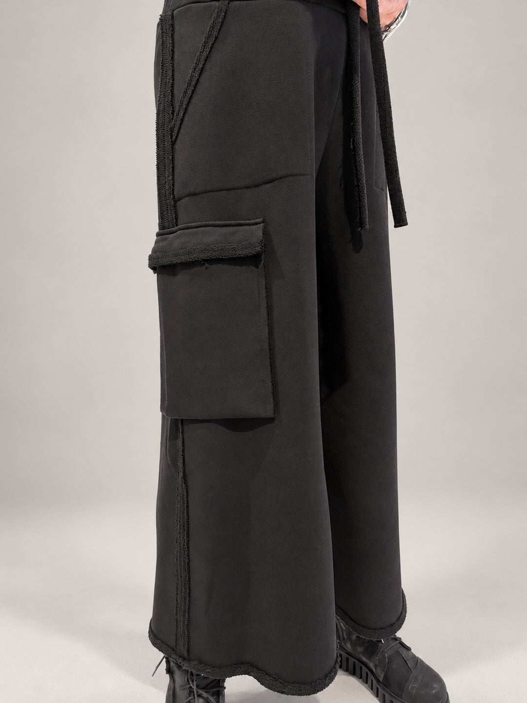Kedziorek black cotton trousers, close-up of oversized cargo pocket and loopback seam edging