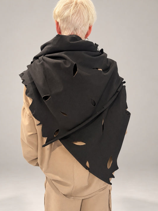 Kedziorek black scarf draped across the back, showing leaf-shaped cut-outs and irregular edge