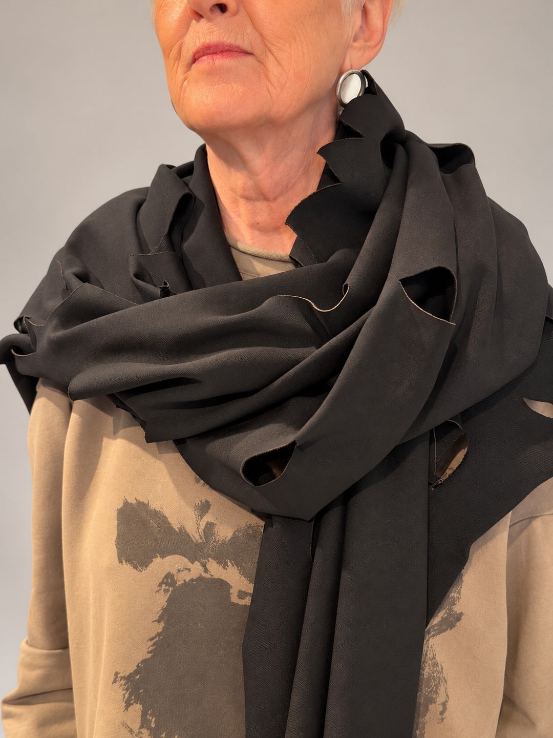 Kedziorek black cotton-blend scarf, close-up of folded neckline drape and leaf-shaped cut-outs