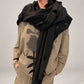 Kedziorek black cut-out scarf draped around the shoulders over a taupe printed top, front view