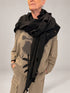 Kedziorek black cut-out scarf draped around the shoulders over a taupe printed top, front view