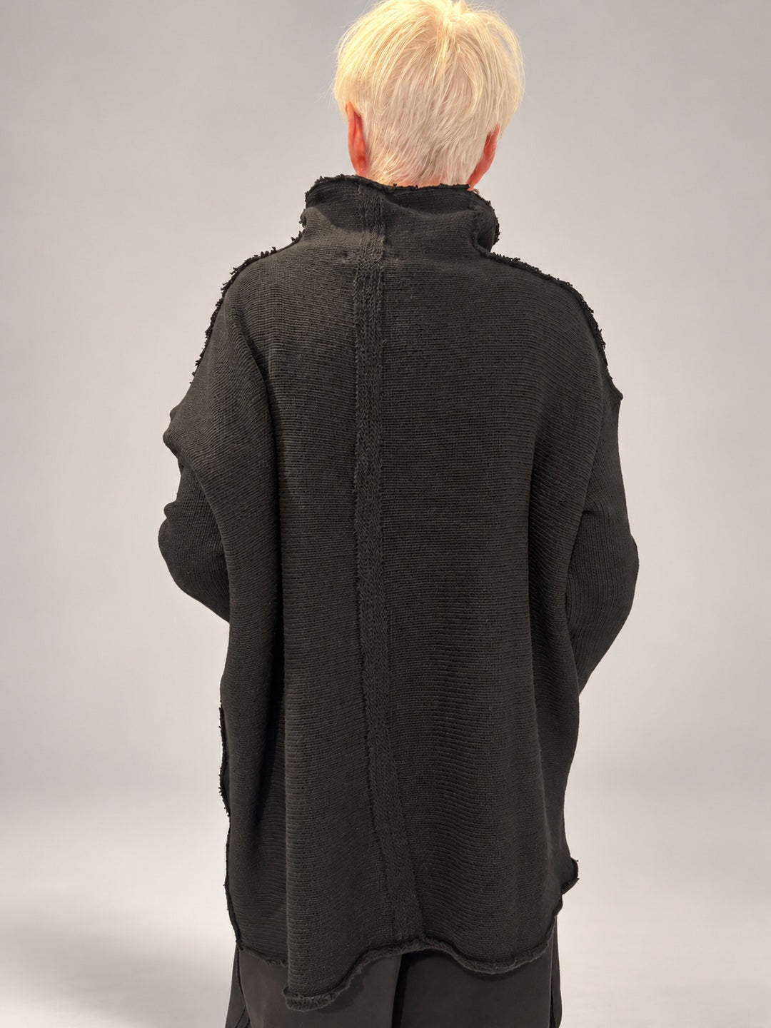 Kedziorek black textured merino wool top, back view showing longer hem and exposed centre seam