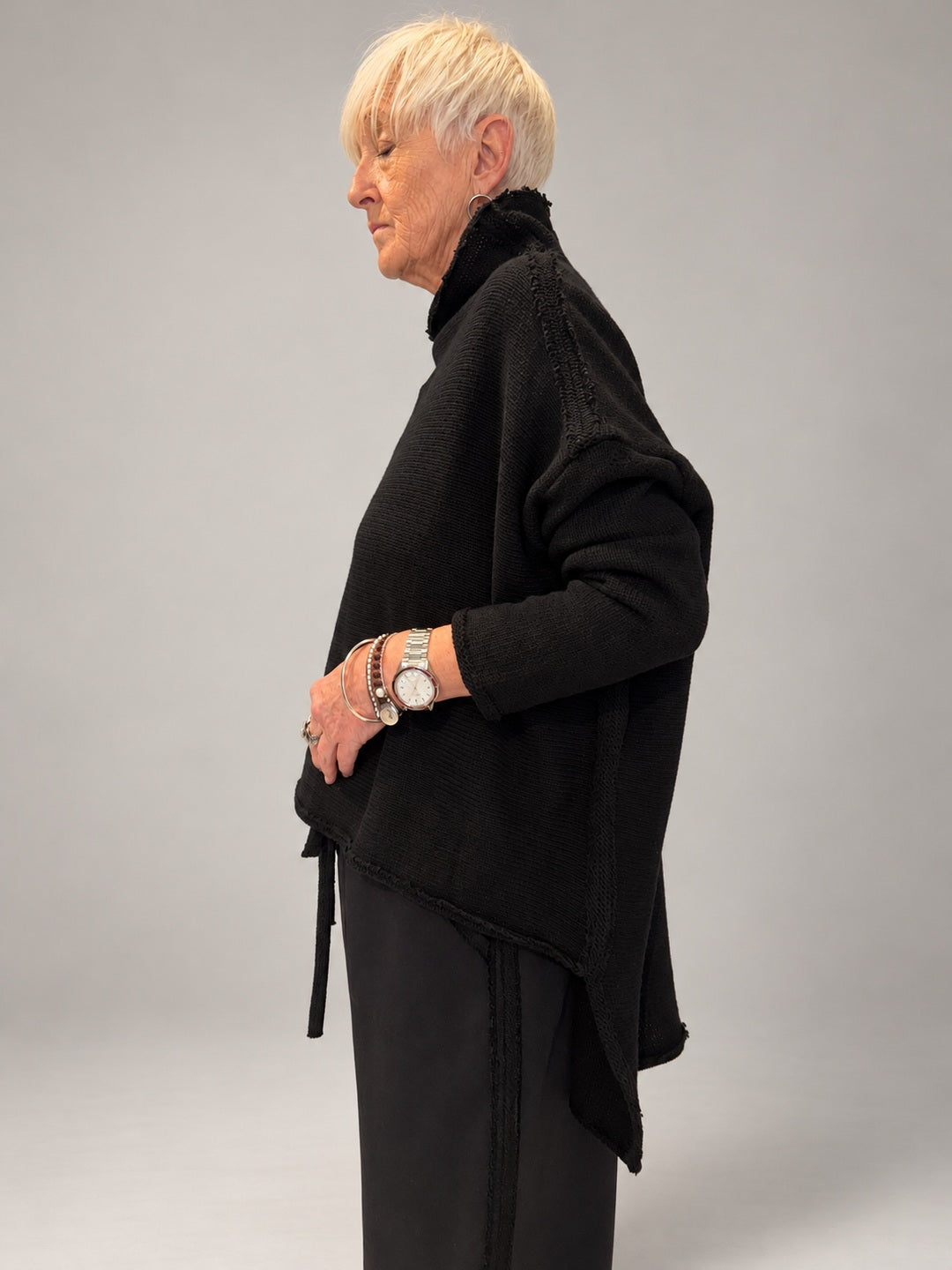 Kedziorek black textured merino wool top, side view showing dropped shoulder and longer back hem