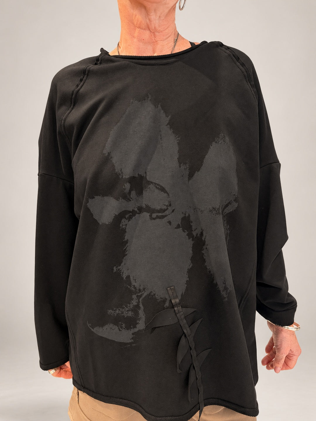 Kedziorek black floral print top with ribbon leaf detail, relaxed sleeves and exposed seams, front view