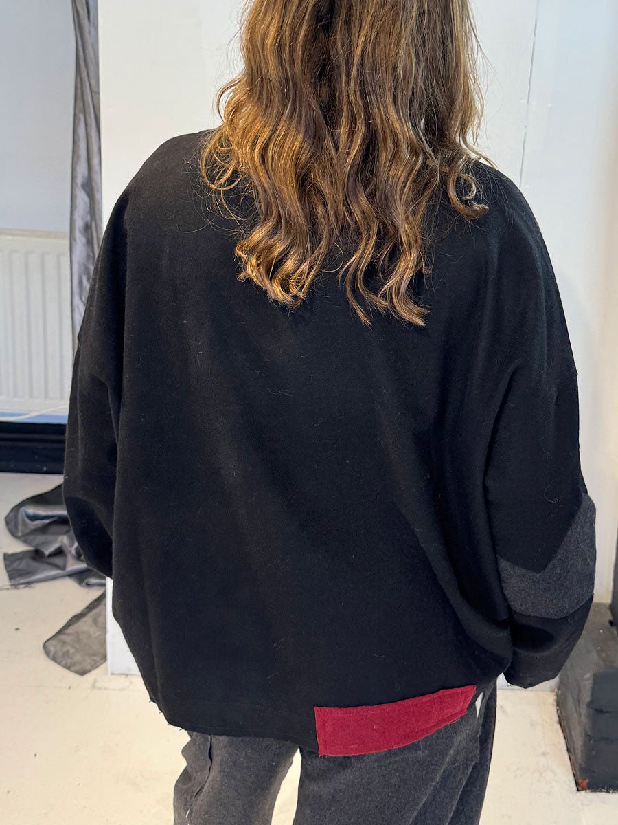 La Vaca Loca Tratado jumper, side view showing red hem accent