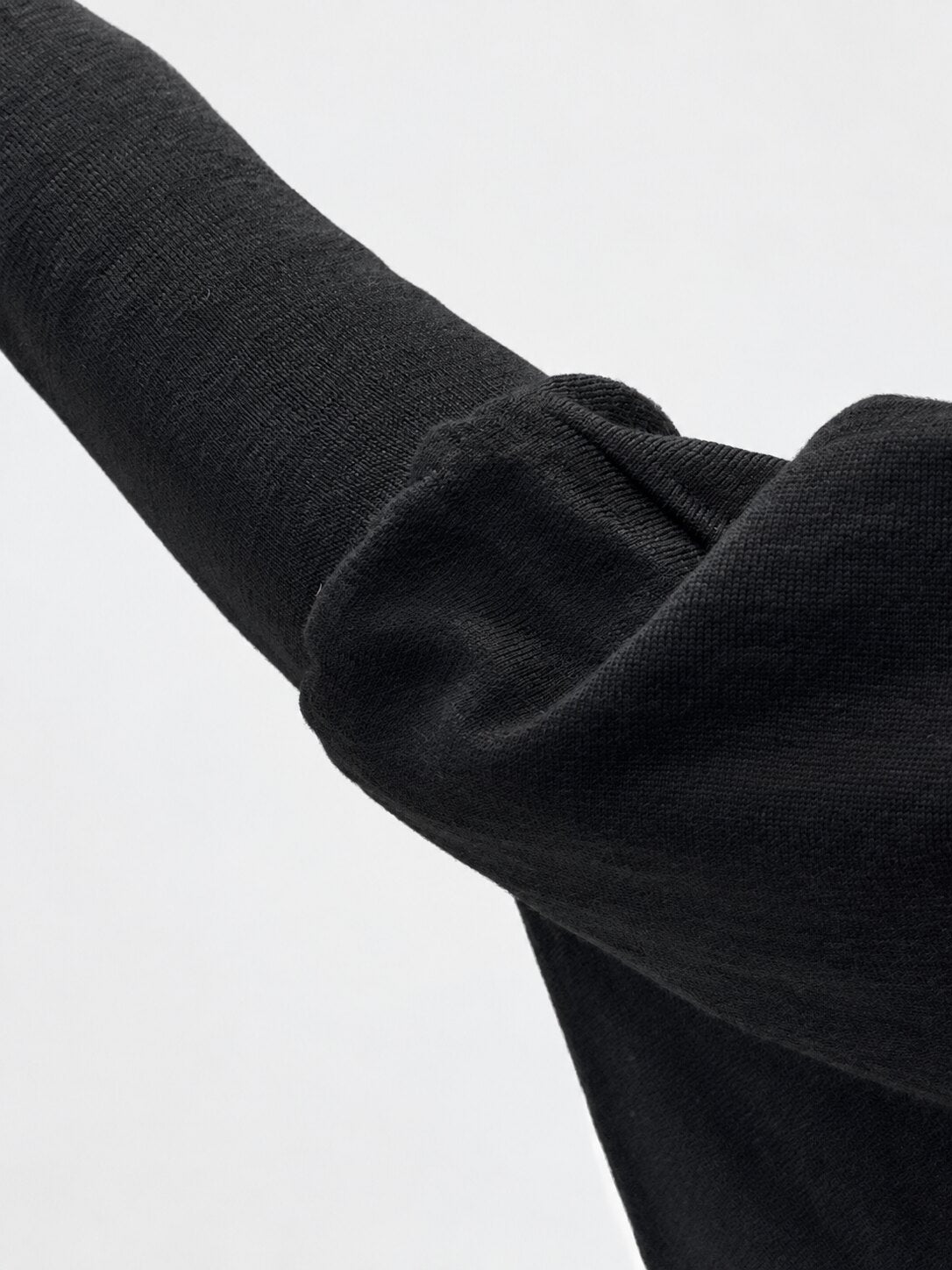 Transit black virgin-wool jumper – fitted sleeve and draped-arm detail