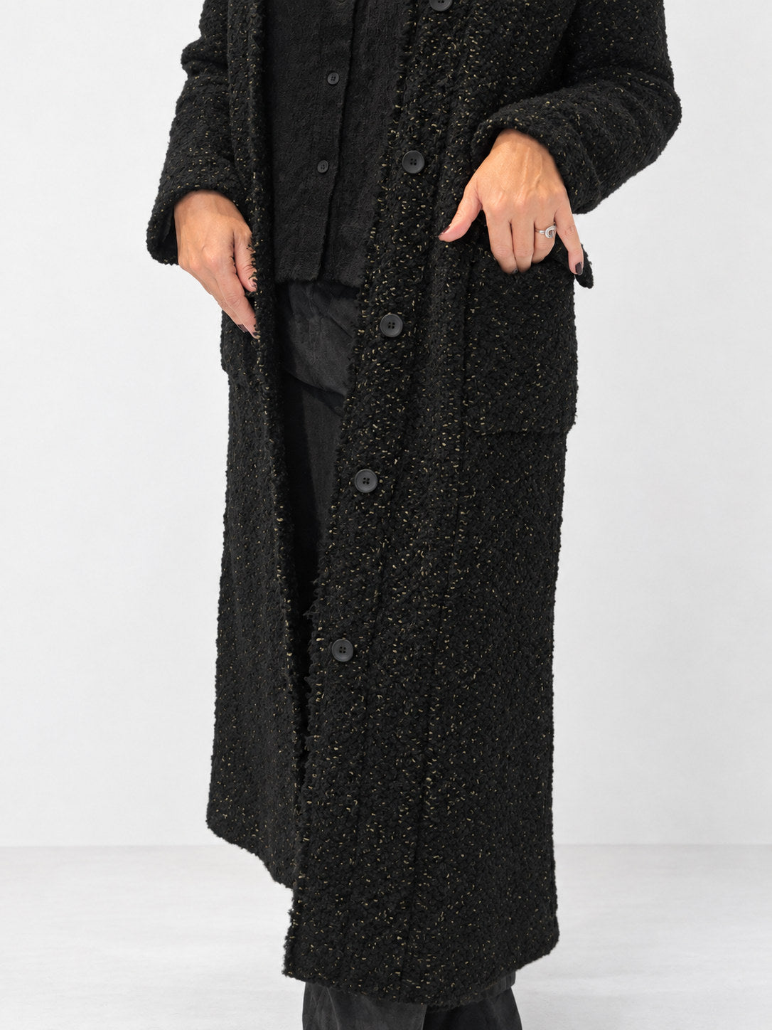Transit black textured long coat – button placket and flap-pocket detail