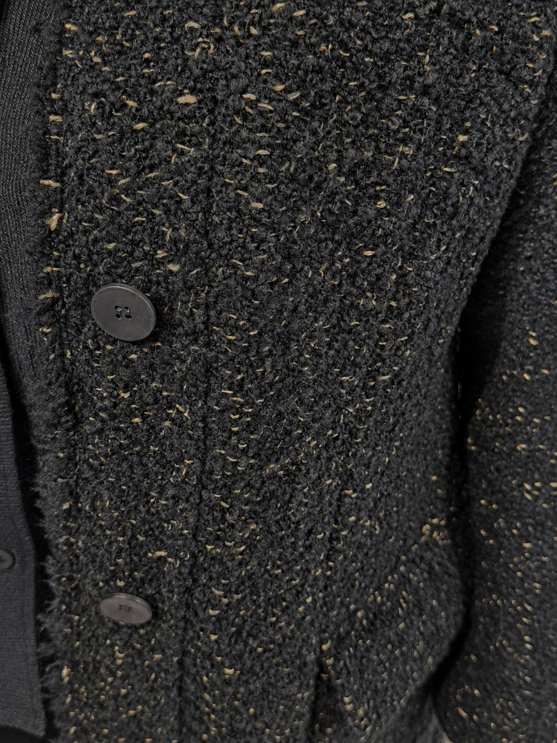 Transit black long coat – close-up of flecked texture and tonal buttons